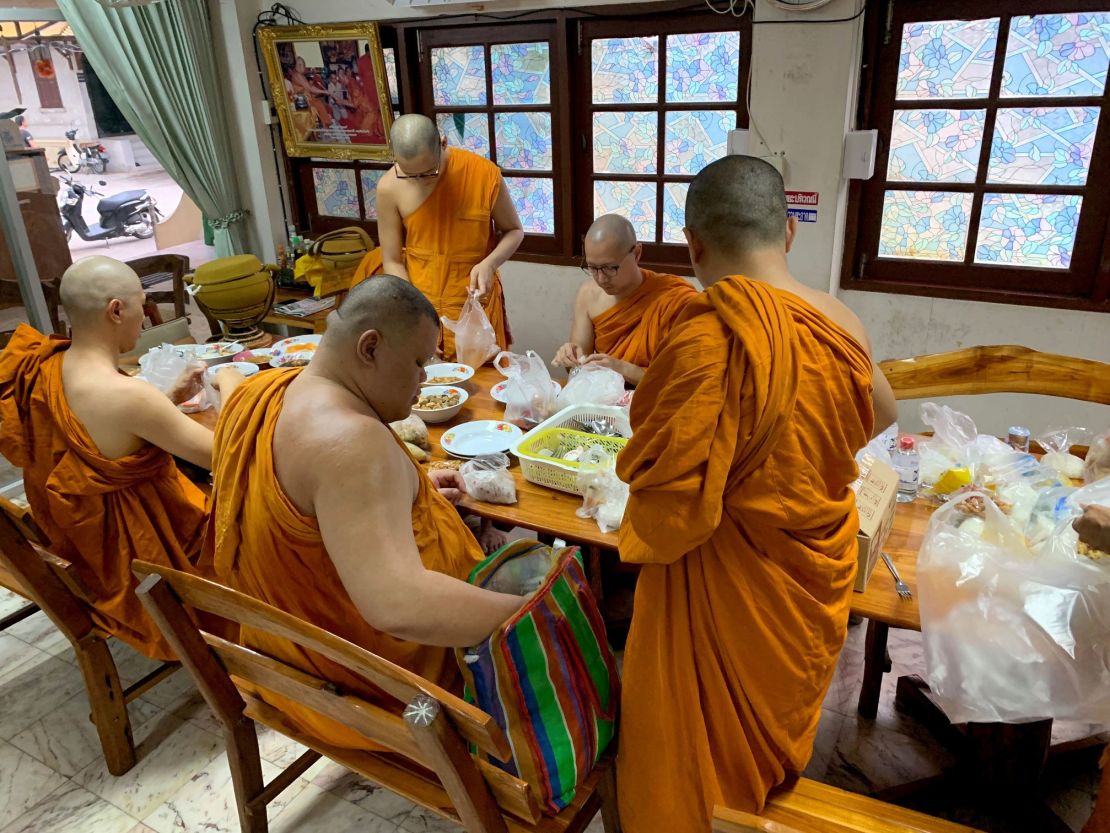 Monks at Yannawa temple in Bangkok prepare to eat. 