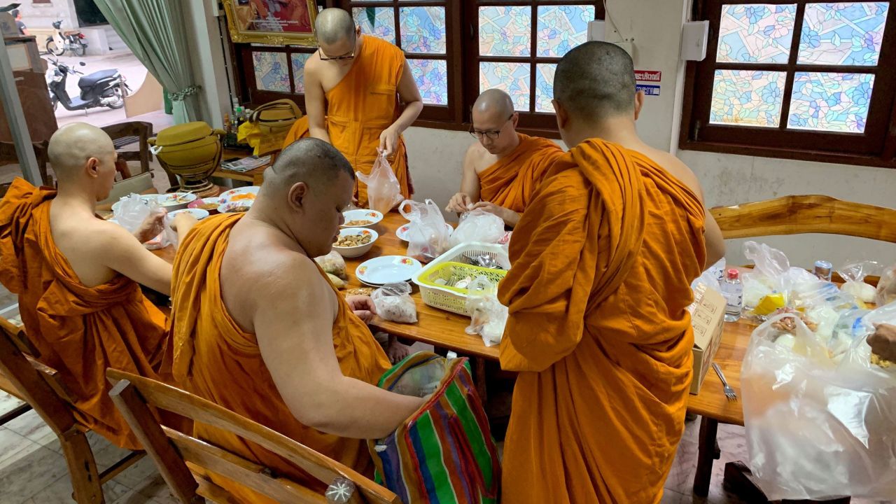 Monks at Yannawa temple in Bangkok prepare to eat.