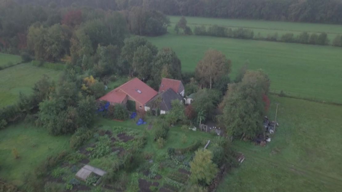 The farm is shielded by trees and appears to have a vegetable garden.