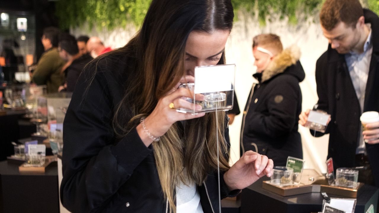 A customer smells a sample as she shops for cannabis on the first morning of opening for Toronto's "Hunny Pot," one of the retail stores licensed to sell cannabis in Ontario on Monday, April 1, 2019. (Chris Young/The Canadian Press via AP)
