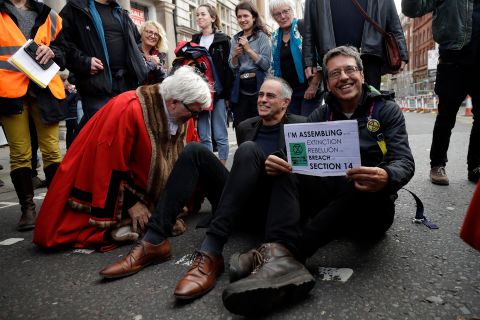 The Guardian newspaper environmental journalist and author George Monbiot, right, sits blocking a road with the Co-Leader of Britain's Green Party Jonathan Bartley at the bottom of Trafalgar Square on October 16. 