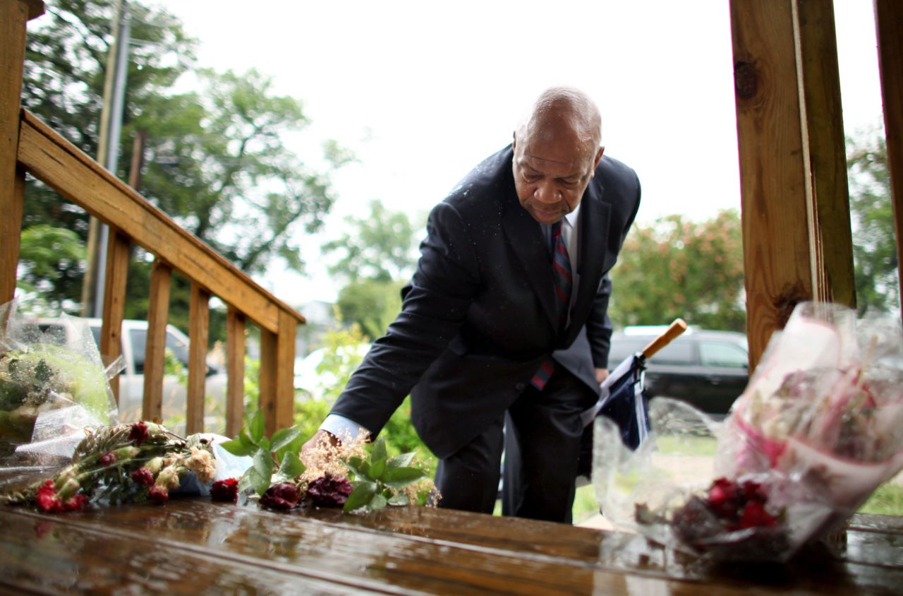 Cummings rearranges flowers on the stairs of the house where his nephew, Christopher Cummings, was killed in a June 2011 shooting in Norfolk, Virginia.