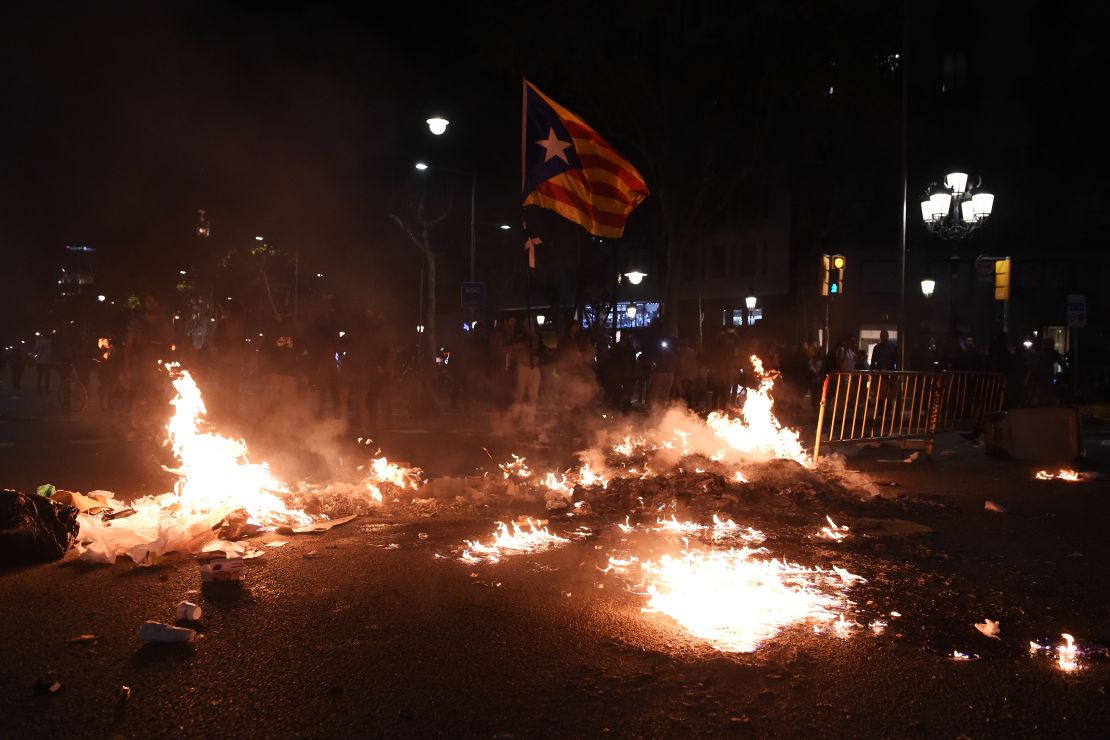 A Catalan flag flies above burning rubbish in Barcelona on October 15. 