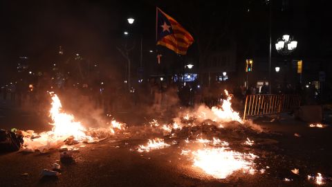 A Catalan flag flies above burning rubbish in Barcelona on October 15. 