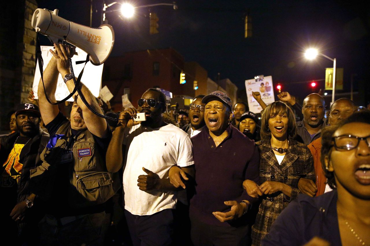 Cummings marches with protesters in Baltimore after authorities released a report on the death of Freddie Gray.