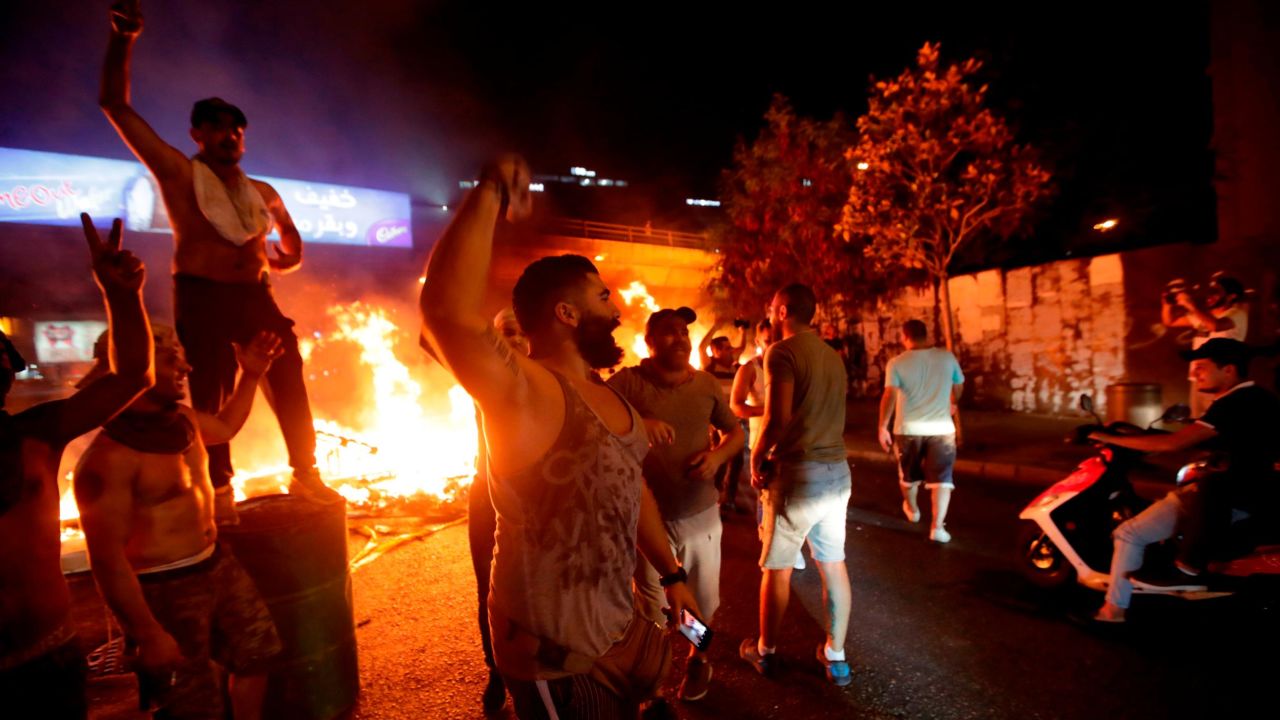 Lebanese demonstrators chant slogans as a fire burns in the capital Beirut.