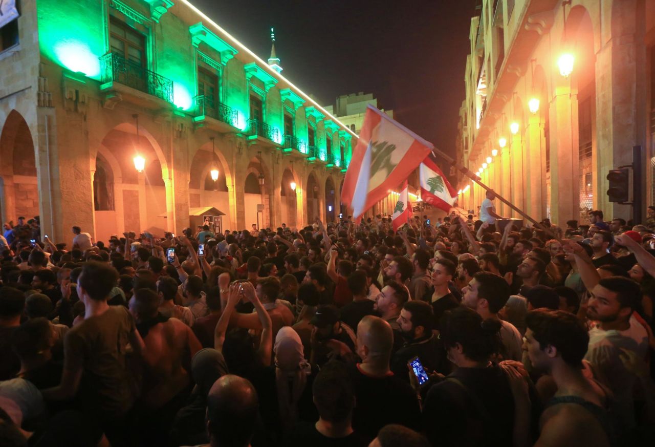 Demonstrators wave flags outside the government palace in Beirut on October 17.