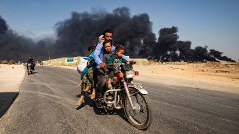 Displaced people ride a motorcycle on the outskirts of Tal Tamr, Syria, on Wednesday, October 16.