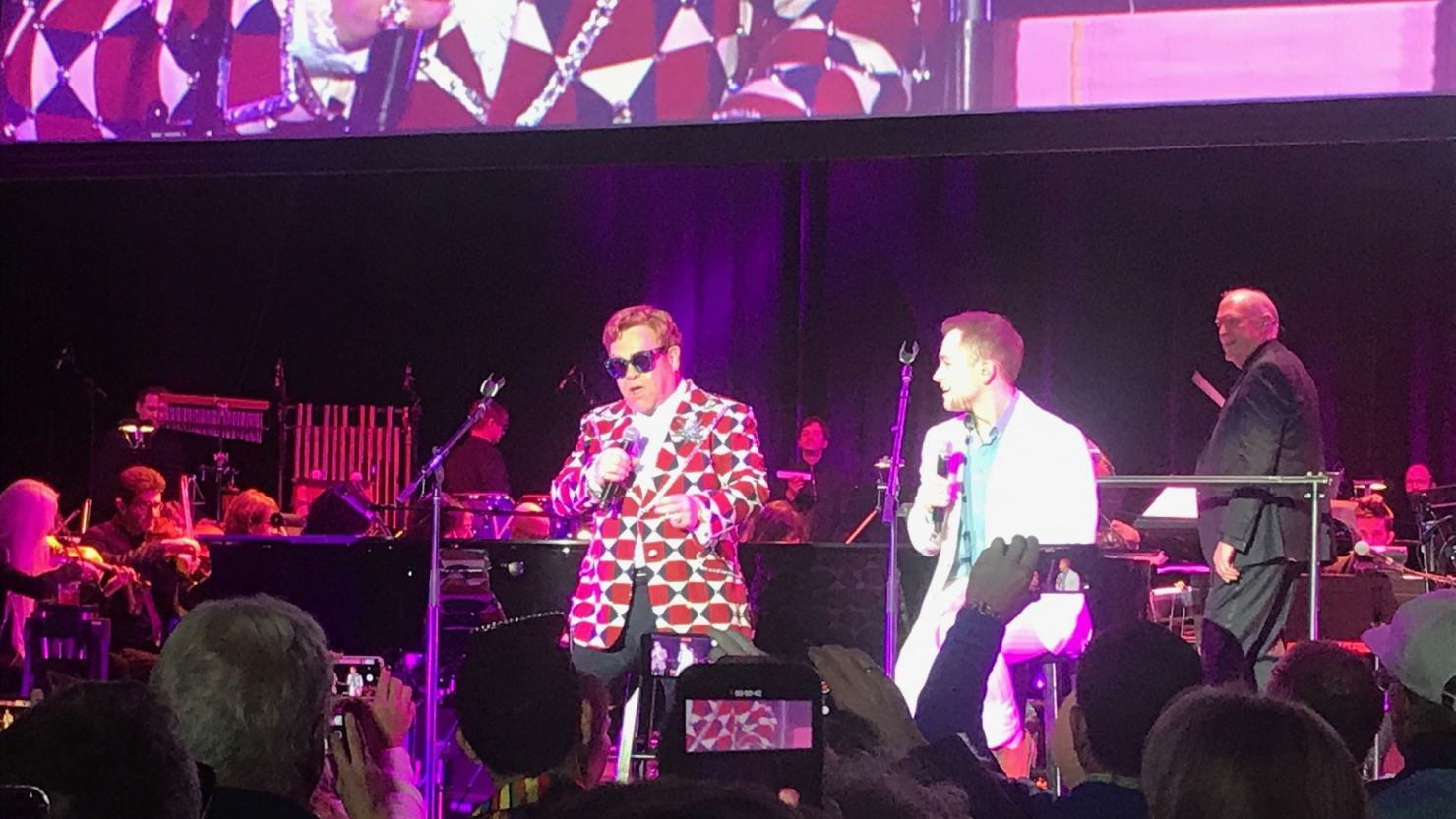 Elton John and the actor who played him in ìRocketmanî Taron Egerton sing after the Hollywood Orchestra played along to the movie.