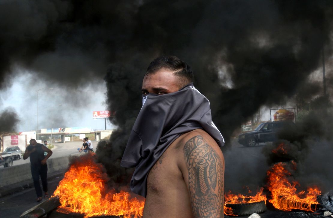 A Lebanese demonstrator stands in front of a tire fire on Friday.