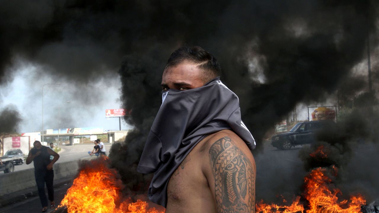 A Lebanese demonstrator stands in front of a tire fire on Friday.