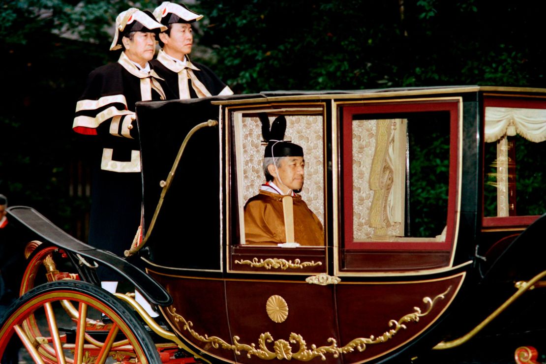 Japanese Emperor Akihito sits in a carriage on his way to perform a ritual to mark the completion of his enthronement on November 28, 1990.