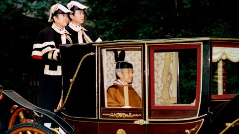 Japanese Emperor Akihito sits in a carriage on his way to perform a ritual to mark the completion of his enthronement on November 28, 1990.