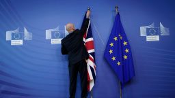 TOPSHOT - An official hangs a Union Jack next to an European Union flag at EU Headquarters in Brussels on October 17, 2019, ahead of a European Union Summit on Brexit. (Photo by Kenzo TRIBOUILLARD / AFP) (Photo by KENZO TRIBOUILLARD/AFP via Getty Images) 