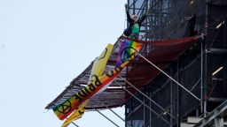 A climate activist dressed as Britain's Prime Minister Boris Johnson gestures after climbing scaffolding and unfurling banners on the Elizabeth Tower, commonly known by the name of the bell, Big Ben on the twelfth day of demonstrations by the climate change action group Extinction Rebellion, in London, on October 18, 2019. - The Extinction Rebellion pressure group has been staging 10 days of colourful but disruptive action across London and other global cities to draw attention to climate change. (Photo by Tolga AKMEN / AFP) (Photo by TOLGA AKMEN/AFP via Getty Images)