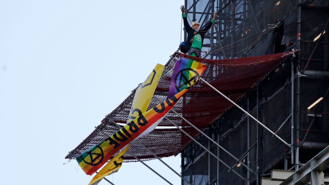 Extinction Rebellion activist Ben Atkinson unfurls a banner on the scaffolding surrounding Big Ben.