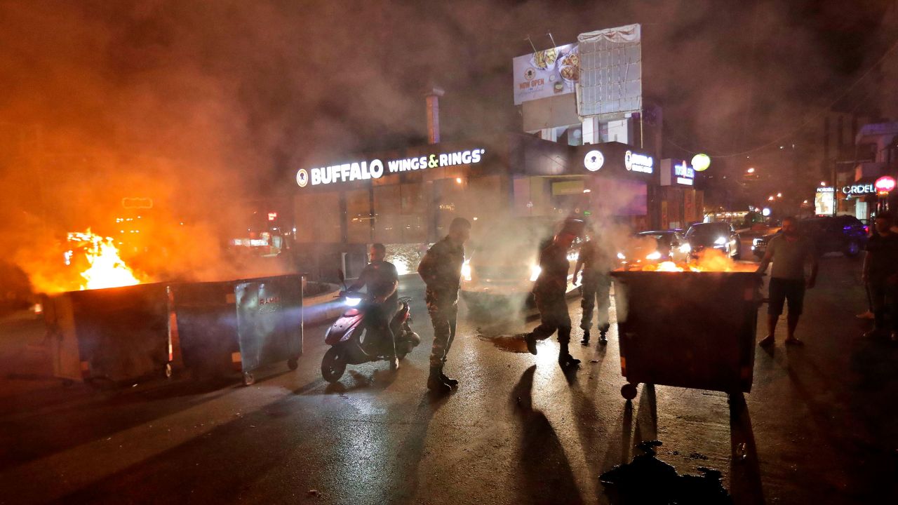 Lebanese security forces move dumpsters to open up the main Beirut-Tripoli highway, near the town of Kaslik north of the Lebanese capital.
