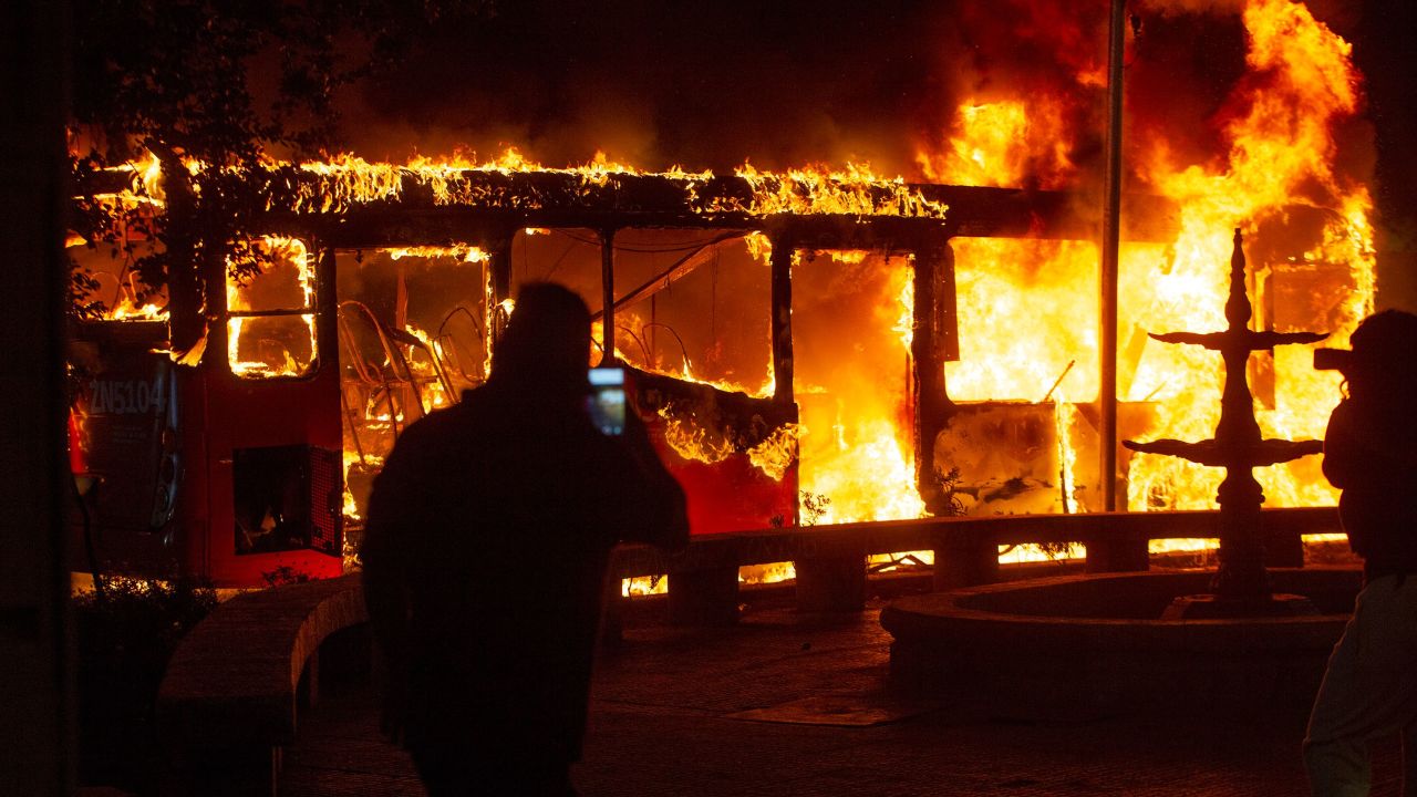 A bus burns in central Santiago on Friday in the wake of protests over fare hikes.
