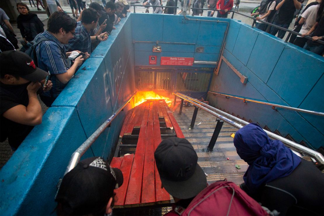 Protesters burn an entrance to Santa Lucia metro station in Santiago on Friday.