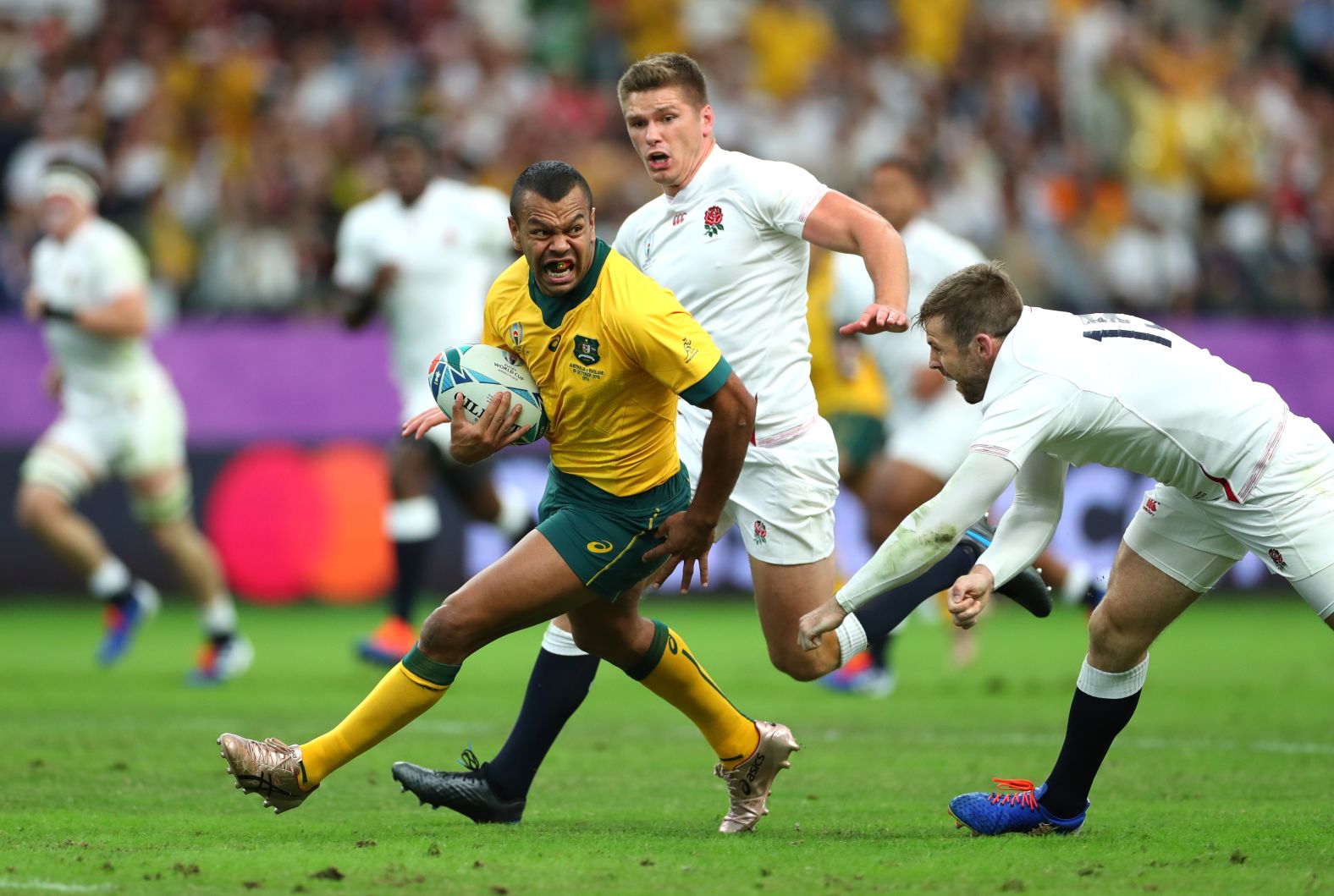 Kurtley Beale of Australia evades Owen Farrell and Elliot Daly of England.