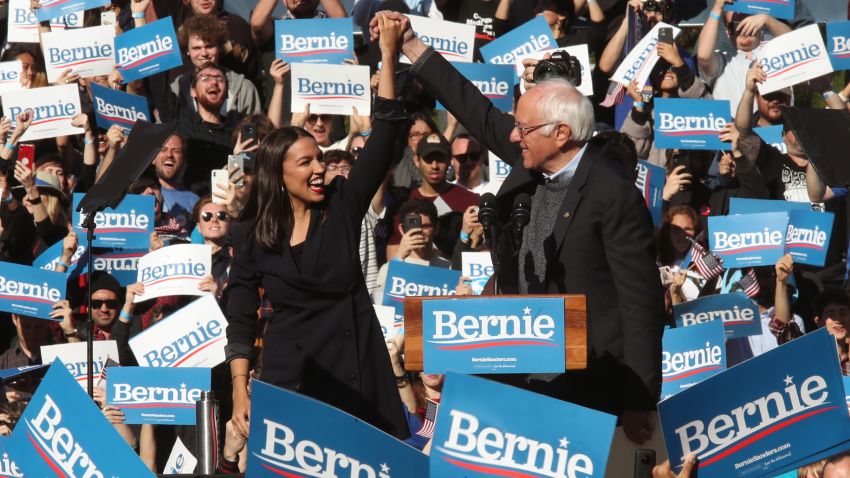 Rep. Alexandria Ocasio-Cortez, D-N.Y., clasps hands with Democratic presidential candidate Sen. Bernie Sanders, I-Vt., after introducing Sanders during a campaign rally on Saturday, Oct. 19, 2019 in New York. (AP Photo/Mary Altaffer)