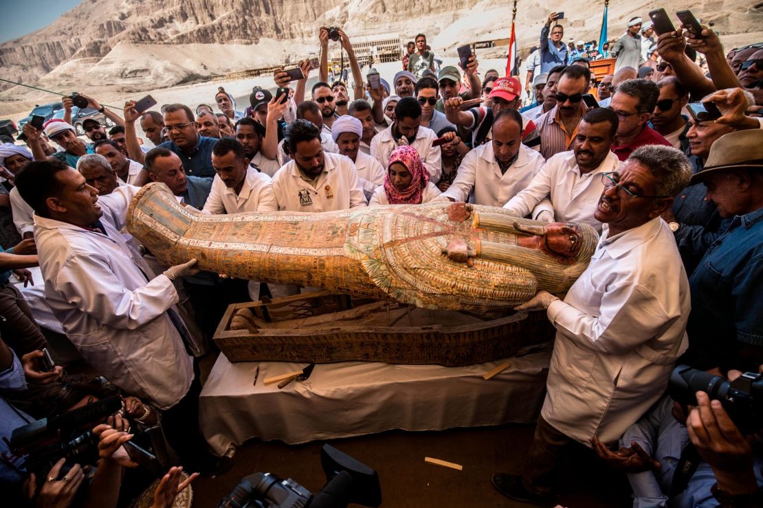 Egyptian archeologist open a coffin belonging to a man in front Hatshepsut Temple in Luxor on October 19, 2019.