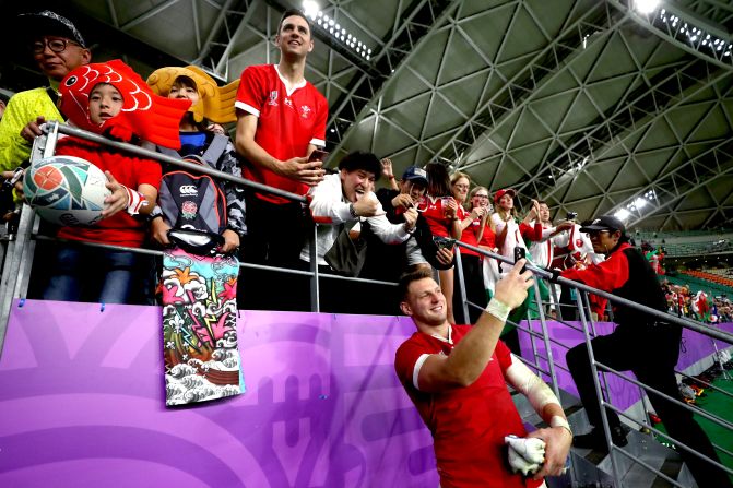Wales' Dan Biggar takes selfies with fans at the end quarterfinal.