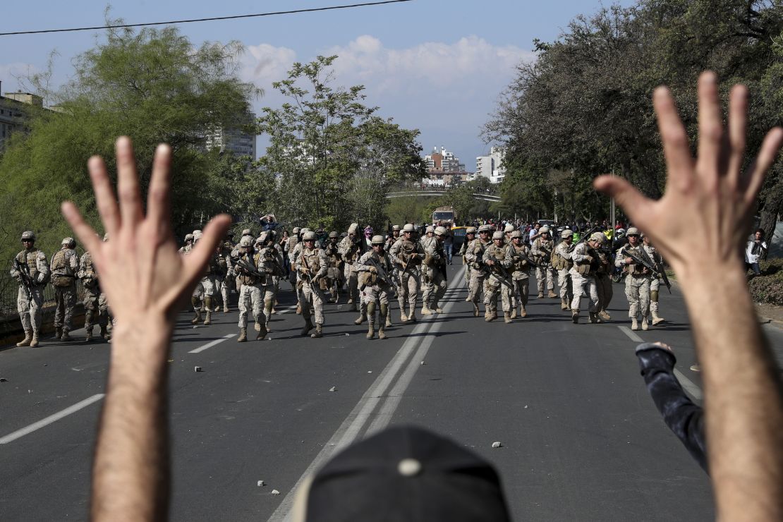 A demonstrator holds up his hands toward advancing soldiers during a protest in Santiago, Chile, on October 20.