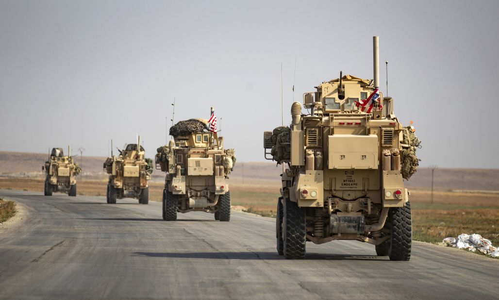US military vehicles drive after pulling out of their base in the northern Syrian town of Tal Tamr on Sunday, October 20.