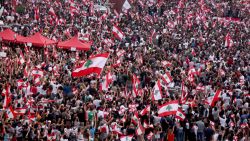 Lebanese demonstrators wave national flags as they take part in a rally in the capital Beirut's downtown district on October 20, 2019. - Thousands continued to rally despite calls for calm from politicians and dozens of arrests. The demonstrators are demanding a sweeping overhaul of Lebanon's political system, citing grievances ranging from austerity measures to poor infrastructure. (Photo by Patrick BAZ / AFP) (Photo by PATRICK BAZ/AFP via Getty Images)