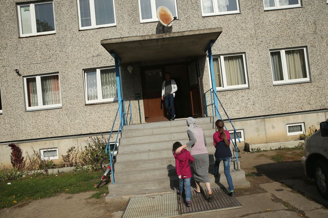 A Chechen family seeking asylum in Germany walk into their temporary home in Letschin. 