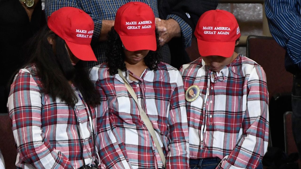 In this October 2018 file photo, three supporters bow their heads as a prayer is said at a campaign rally held by President Donald Trump in Rochester, Minnesota. 