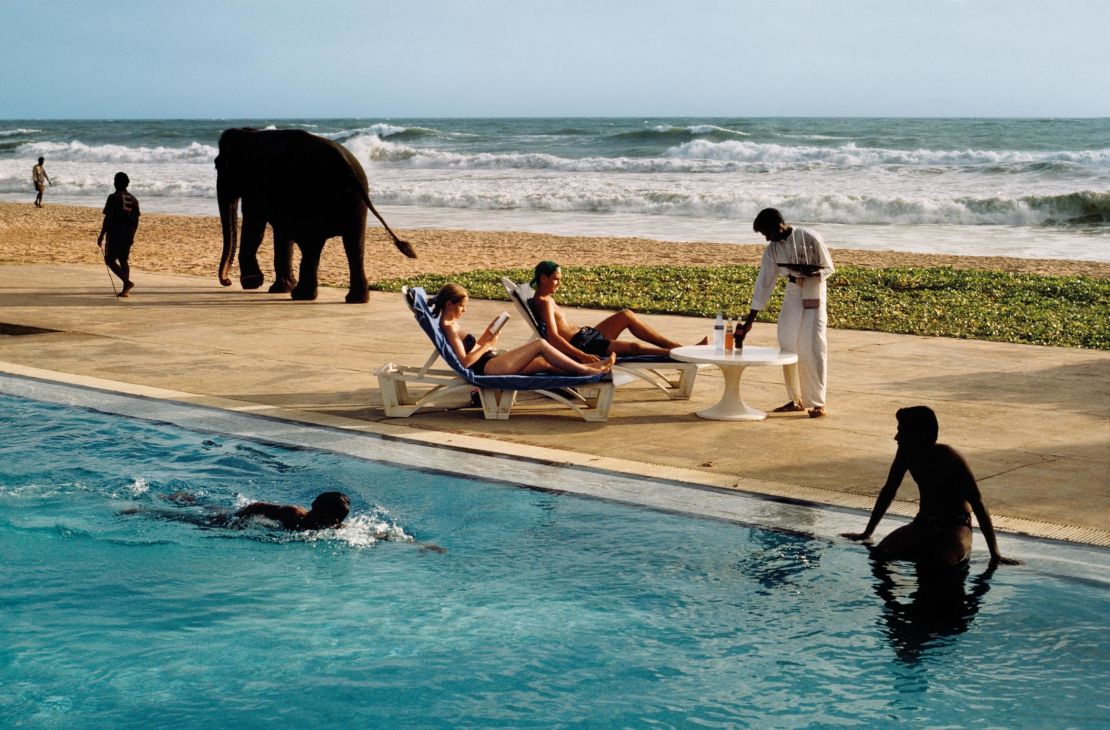 Tourists lounge poolside as an elephant passes in Bentota, Sri Lanka. 1995.