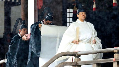 Japan's Emperor Naruhito, in a white robe, leaves after praying at "Kashikodokoro", one of three shrines at the Imperial Palace, in Tokyo, on October 22, 2019.  