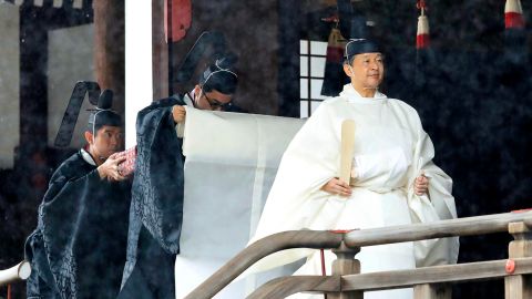 Japan's Emperor Naruhito, in a white robe, leaves after praying at "Kashikodokoro", one of three shrines at the Imperial Palace, in Tokyo, on October 22, 2019.