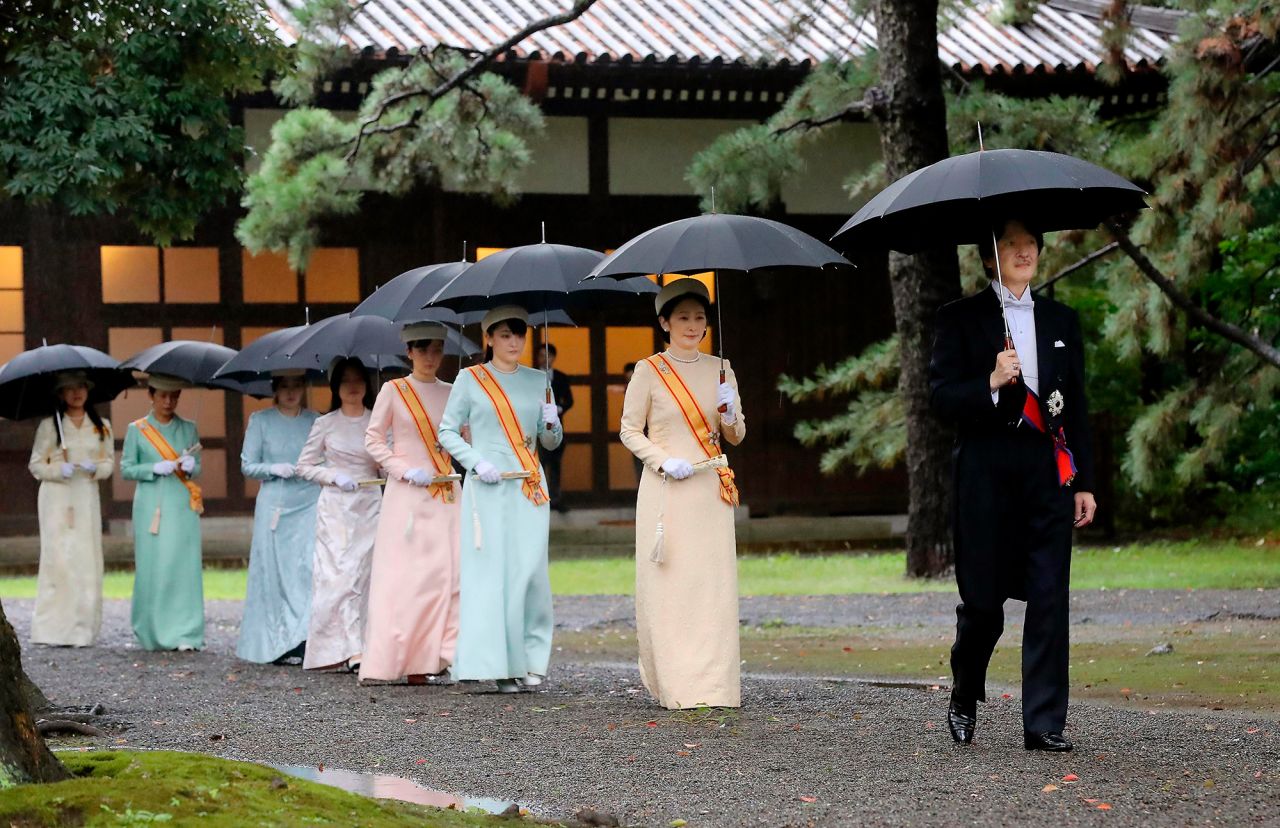 Japan's Crown Prince Akishino, right, and Crown Princess Kiko, second from right, arrive for the ceremony at Kashikodokoro, one of three shrines at the Imperial Palace.