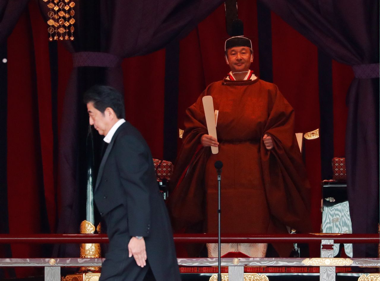 Japan's Prime Minister Shinzo Abe walks past Emperor Naruhito during his enthronement ceremony.