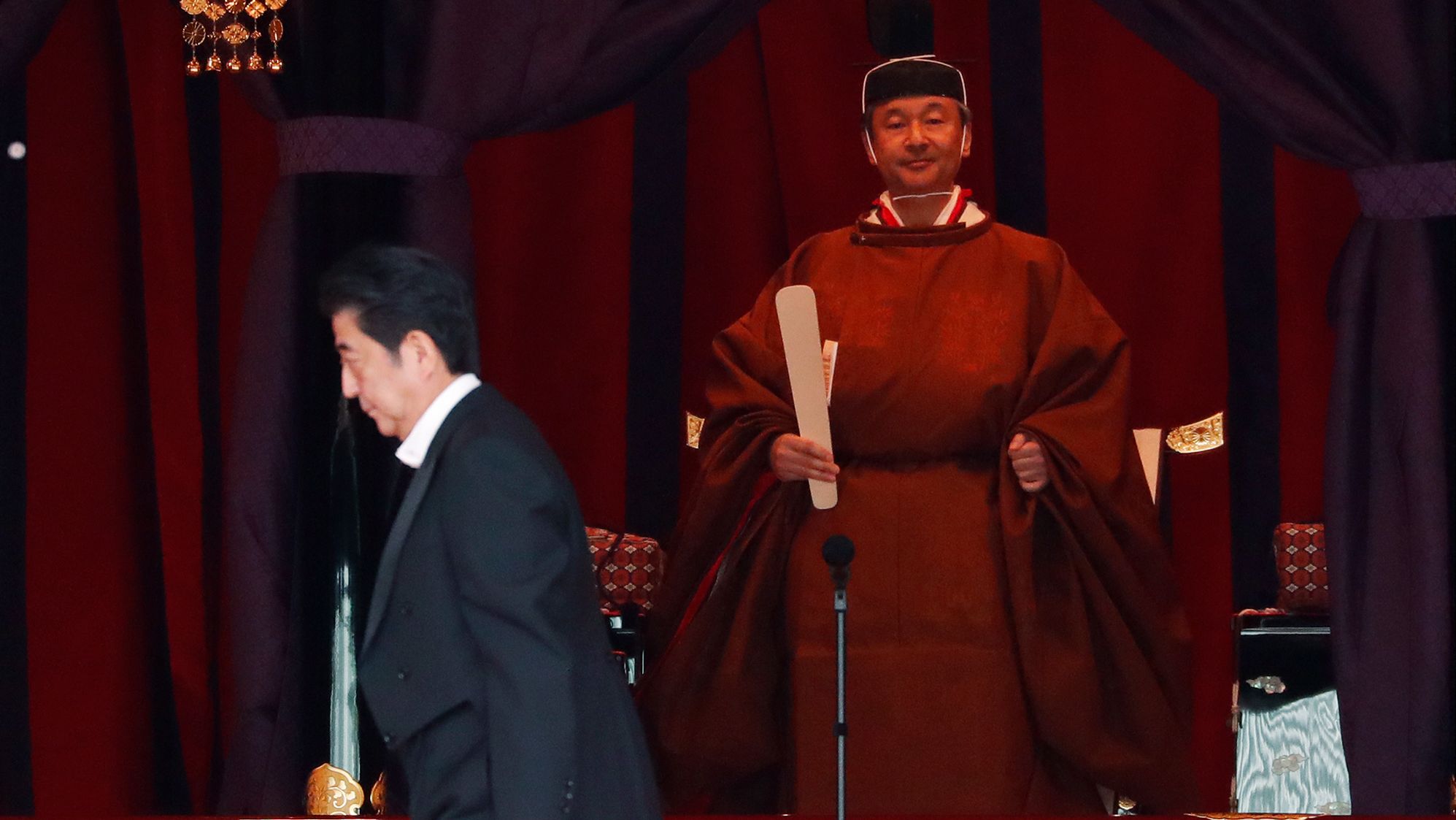 Japan's Prime Minister Shinzo Abe walks past Emperor Naruhito during his enthronement ceremony.