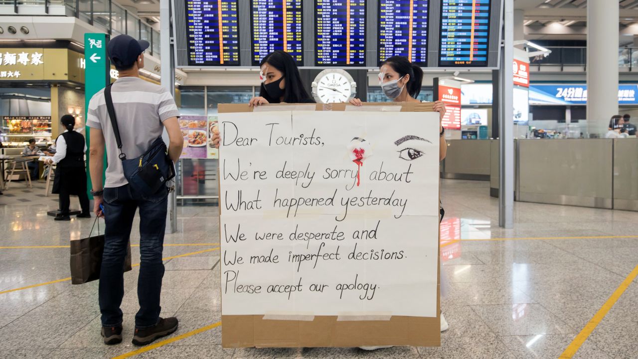 Demonstrators hold an apology sign at the Hong Kong International Airport on August 14, 2019.