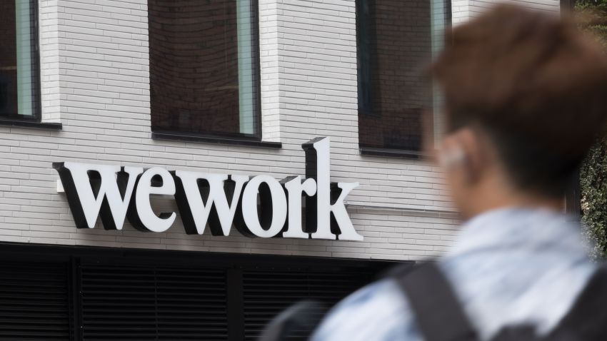 A pedestrian walks past a logo for WeWork the co-working office space, operated by the parent company We Co., on City Road in London, U.K., on Monday, Oct. 7, 2019. While WeWork has been rapidly expanding in Canada, the New York-based company is facing challenges on multiple fronts with Landlords in London and New York amongst the most exposed to any further deterioration at the co-working firm. Photographer: Bryn Colton/Bloomberg via Getty Images