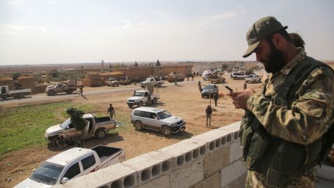 Turkey-backed Syrian fighters gather on a road between the northern Syrian towns of Tal Abyad and Kobani.
