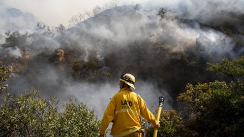 A firefighter looks out over the flames of the Palisades Fire on Oct. 21, 2019, in the Pacific Palisades section of Los Angeles. 