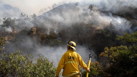 A firefighter looks out over the flames of the Palisades Fire on Oct. 21, 2019, in the Pacific Palisades section of Los Angeles.
