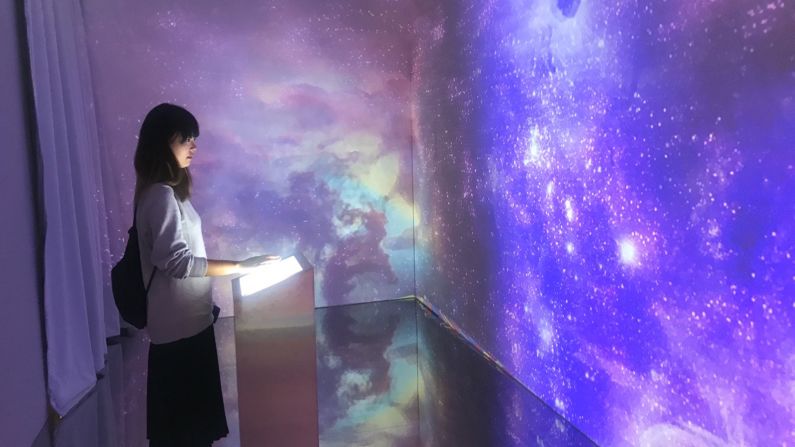 <strong>Joining in:</strong> A fan uses the touchpad installed in an interactive showroom that features the space background from BTS's "DNA" music video.