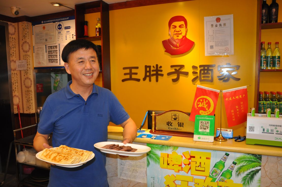 Wang Haibo, regional head of Fat Wang's Donkey Burgers, with a sample of the store's signature products in Beijing in September.