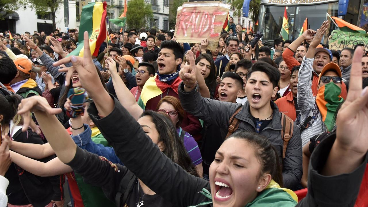 Supporters of Bolivia's main opposition presidential candidate, former president (2003-2005) Carlos Mesa, shout slogans against supporters of president and candidate Evo Morales, as both groups gather outside the hotel where the Supreme Electoral Tribunal has its headquarters to count the election votes, in La Paz, on October 21, 2019. - Evo Morales, seeking a controversial fourth term, led Bolivia's presidential election race Sunday but faces a historic second round run-off against Mesa, partial results showed. Morales had 45 percent of the vote to Mesa's 38 percent, the Supreme Electoral Tribunal announced, with most of the votes counted. (Photo by Aizar RALDES / AFP) (Photo by AIZAR RALDES/AFP via Getty Images)