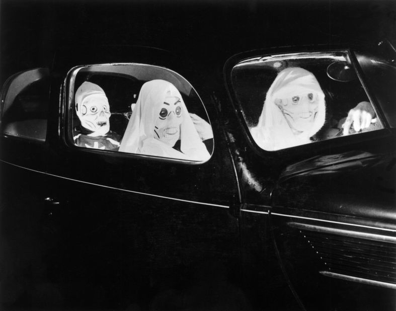  A 1938 image shows three people driving to a party in hair-raising skull masks.