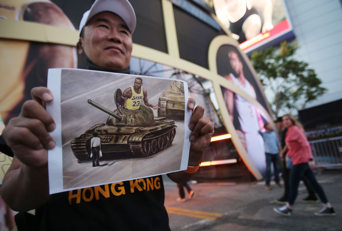  A pro-Hong Kong activist holds an image depicting LeBron James aboard a Chinese tank in Tiananmen Square before the Los Angeles Lakers season opening game against the against the LA Clippers outside Staples Center on October 22, 2019.