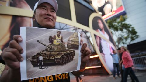 A pro-Hong Kong activist holds an image depicting LeBron James aboard a Chinese tank in Tiananmen Square before the Los Angeles Lakers season opening game against the against the LA Clippers outside Staples Center on October 22, 2019.