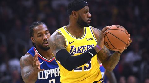 LeBron James, right, of the Lakers is defended by Kawhi Leonard of the Clippers during the opening game for both Los Angeles teams on Tuesday. 